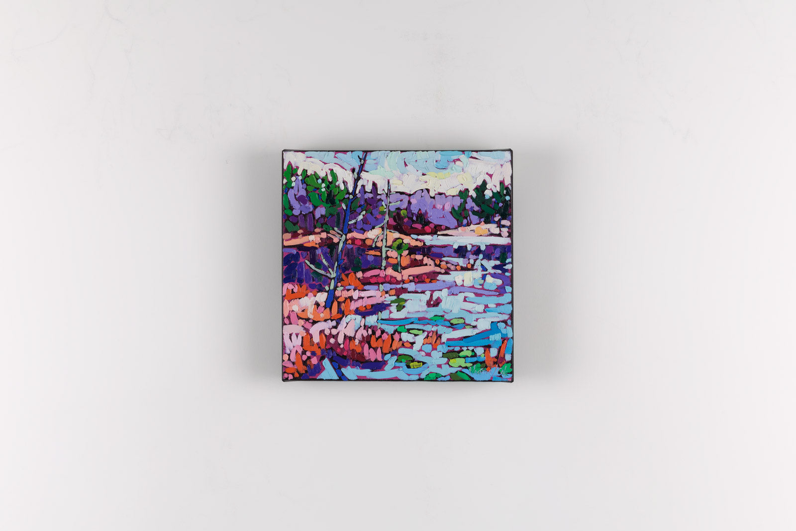 Small square painting of a landscape with trees and water on a white background